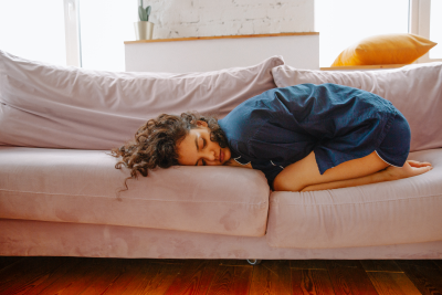 dívka leží na gauči, menstruační bolesti